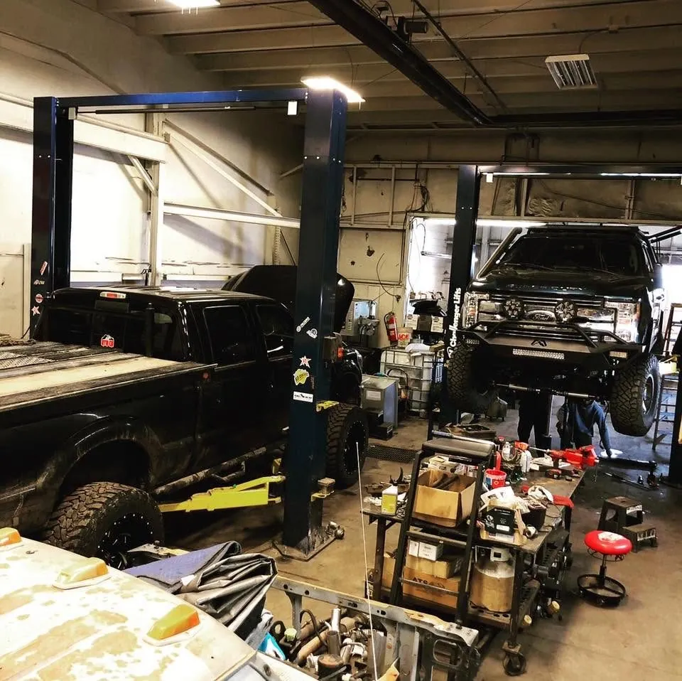 Technician servicing a vehicle climate system at 1-Off Auto Center